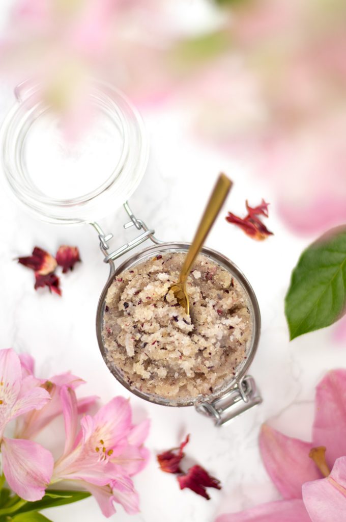 View from above of hibiscus and ylang-ylang sugar scrub in glass jar